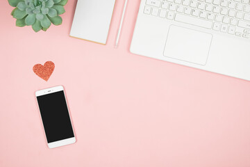 Mobile phone in hand screen on pink background. Love in social media. Women workspace. Happy Valentine's day