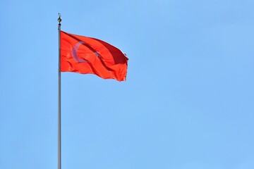 Turkish flag waving in the wind with selective focus on blue sky background. National symbol of Turkey. 