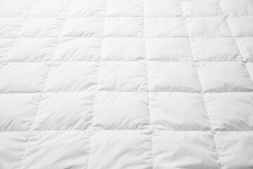 Soft quilted blanket as background, closeup view