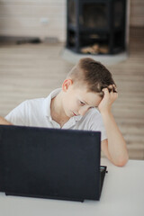 A boy learns lessons at home distance learning on a laptop