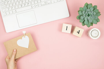 Obraz premium Composition for Valentine's Day February 14th. Delicate pink background, laptop and cosmetics. Greeting card. Flat lay, top view, copy space.