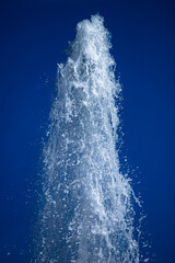 Water jet from a fountain in abstract design on blue sky background. Urban landscape.  Concept.
