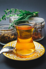 Traditional tea in a glass, tea ceremony with aromatic herbs, mint and honey.