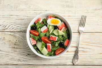 Delicious crab stick salad served on white wooden table, flat lay