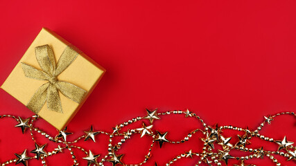 Gift box with a gold bow and gold decoration at the bottom of the frame. Banner. Greeting card for New Year, Christmas, Thanksgiving, Mother's Day, Birthday. A place for a creative concept