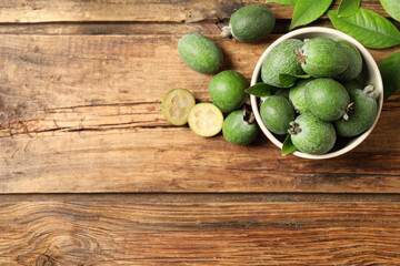 Flat lay composition with fresh green feijoa fruits on wooden table, space for text