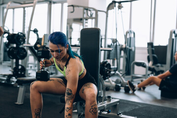 Fototapeta na wymiar tattooed woman training in gym
