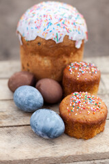 Easter eggs and sweet easter cake on wooden background