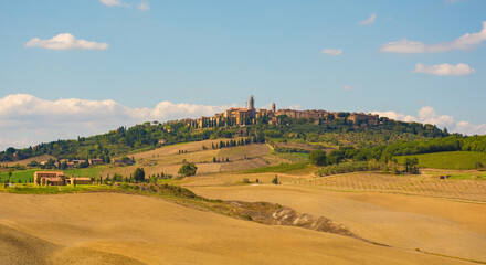 Fototapeta premium The late summer landscape around Monticchiello near Pienza in Val d'Orcia, Siena Province, Tuscany, Italy. Monticchiello village can be seen on the hill in the background 