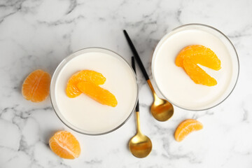 Delicious tangerine jelly on white marble table, flat lay