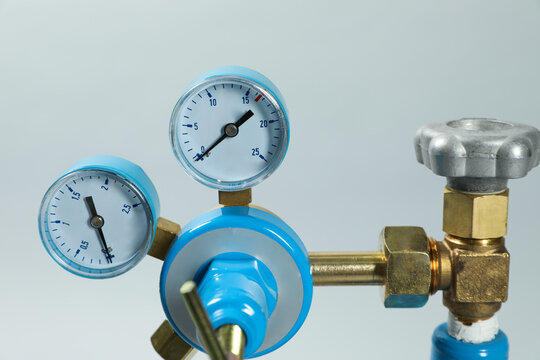 Pressure gauge of medical oxygen tank on light grey background, closeup