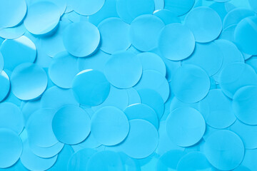 Many light blue confetti as background, top view