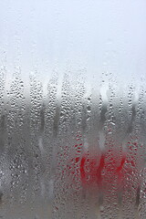 Background of natural condensation of water on transparent glass with high air humidity, large drops dripping