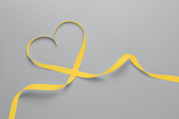 Illuminating ribbon in the shape of a heart on a gray background. Valentine's day concept.