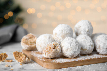 Fototapeta na wymiar Tasty snowball cookies on wooden board, closeup. Christmas treat