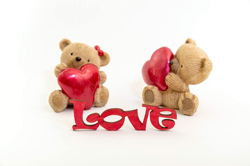 Couple of teddy bears toys and the word love from wooden letters, red hearts. Valentine day concept. Postcard template.