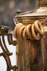 Sushki on a string hanging on old copper Russian samovar