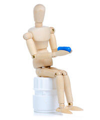 Wooden man with jar pills capsules on white background isolation