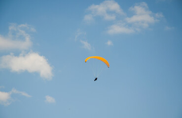 Paraglider flies in the sky over the mountains on a bright sunny day. Paragliding in the sky....