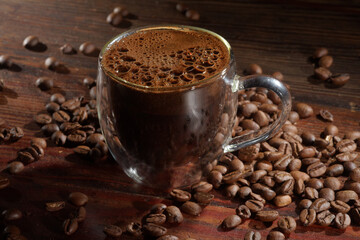 Hot black coffee and coffee beans  on the old wooden table
