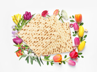 Tasty matzos and flowers on white background, top view. Passover (Pesach) celebration