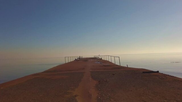 Abandoned pier with clear blue sky