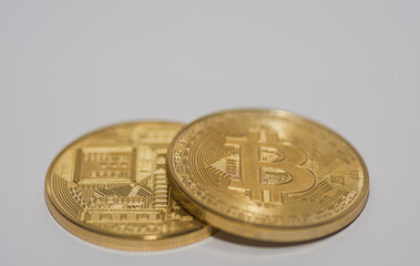 two lying bitcoins with front and back side view on gray