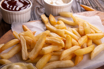 French fries chips potato and sauces on wooden background. top view
