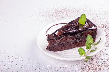Piece of sachr cake on whit plate. Top view, copy space