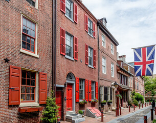 Philadelphia street scene in historical Elfreth's Alley section of the city.  Showing colonial homes with British flag.