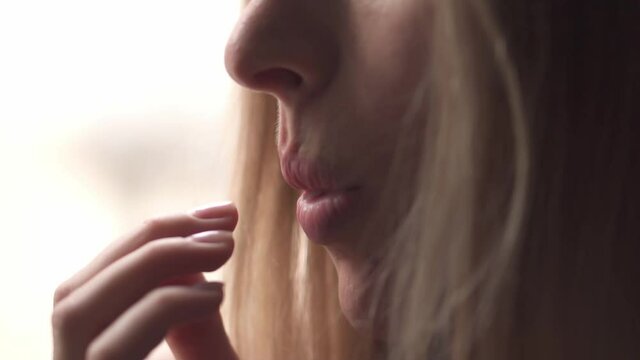Woman eating juicy slice of pomelo, close up portrait
