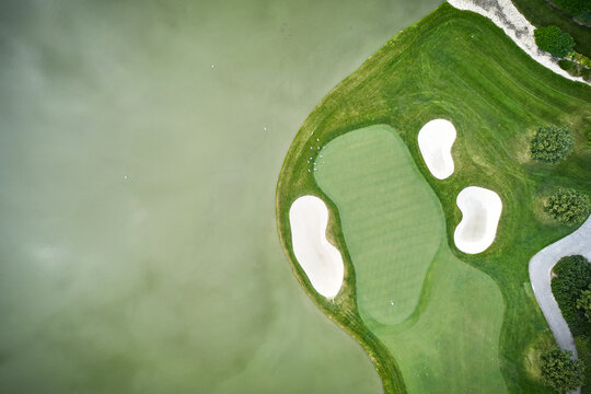 Sand traps and lawn with a lake on a golf course seen from the sky