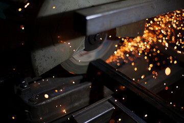 Sparks fly in all directions. Cutting metal with a grinder. Working in a metal workshop. Heating...