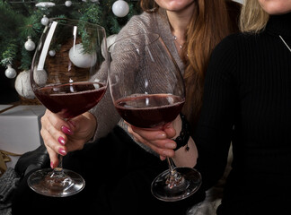 Two glasses of wine in the hands of the girls