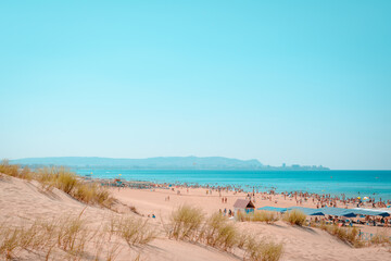 sandy beach on a sunny summer day general background Panorama of the beach. many tourists on the beach in the distance. horizontal photo