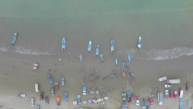 Aerial top view of fisherman that are selling their catch of the day early in the morning 
