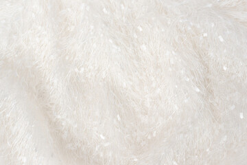 Softness ashion dress made of fleecy, with long pile textile. The texture of the shaggy white fabric with a pile, evenly spread out. Soft  selective focus, close-up shot photo.