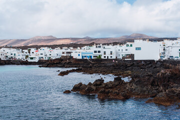 Traditional white houses of the town of Punta Mujeres next to a rocky beach, in the north of the island of Lanzarote