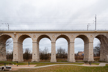 Fototapeta na wymiar Rail viaduct over valley with river Bobr in Boleslawiec, Poland. Entirely built of stone in 1846. One of the longest masonry bridges of its type in Europe. 