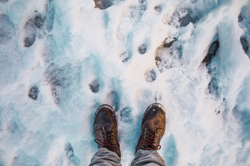 A man walks determined on the ice on a snowy day.