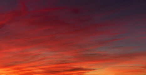 Red orange clouds in the sky at dusk background.