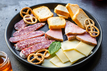 meat platter ham slices, cheese plate and crackers sausage salami tasty ready to eat on the table meal snack outdoor top view copy space for text food background rustic
