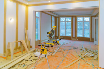 Construction remodeling home with circular saw cutting wood trim molding