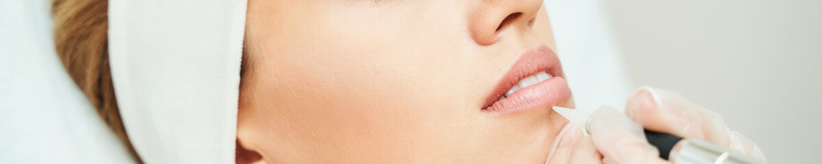 Permanent makeup. Beauty spa procedure. Young woman. Face tattoo. Lip micropigmentation....