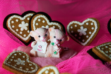 souvenir teddy bears on a pink textile background with hearts and flowers for Valentine's day