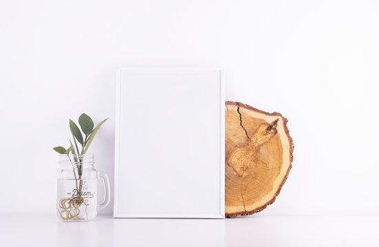 white text frame with indoor decorative plant in a glass vase on a white table