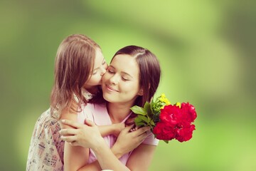 Fototapeta premium Mother and daughter with bouquet of flowers on blurred background.