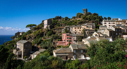 Fototapeta na wymiar The village Nonza, located both the side of a cliff, Cap Corse, Corsica, France. Tower (Tour Paoline) on top of the cliff. 