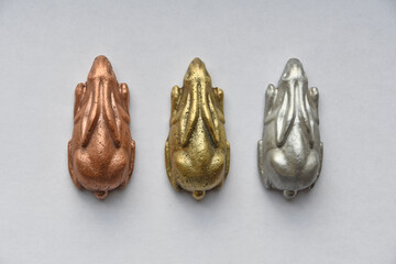 drei Hasen aus Kupfer, Messing und Aluminium in Reihe nebeneinander sitzend