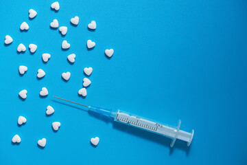 medical blue background. Cardiology. heart-shaped tablets, syringe